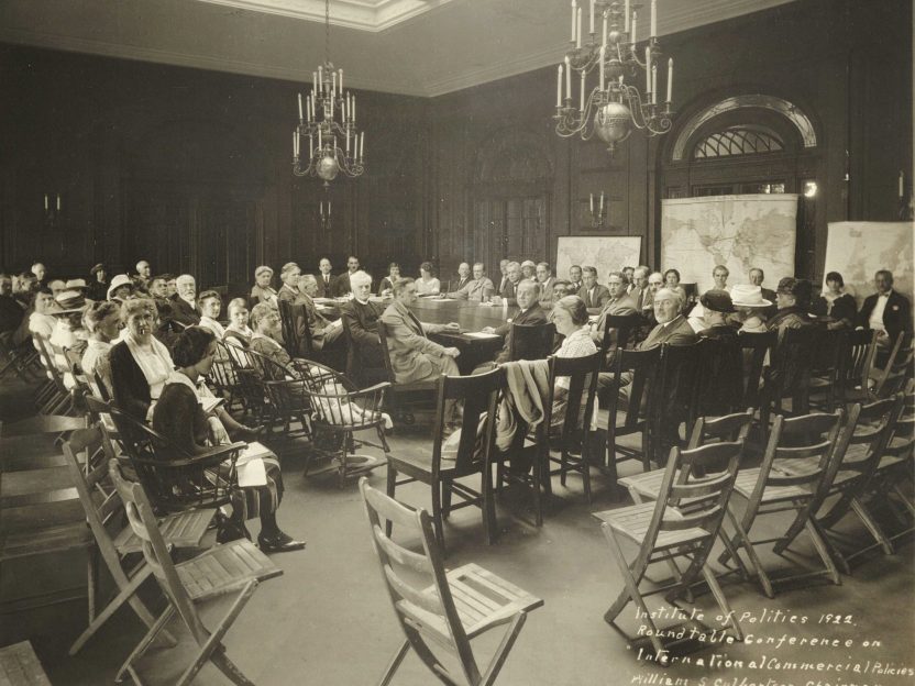 Old photo showing people sitting at a roundtable event