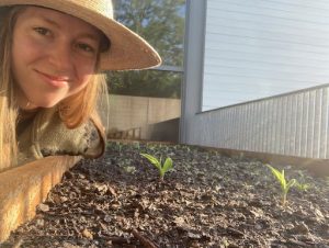 Rosemary Kehoe ’24 poses by budding plants in the garden