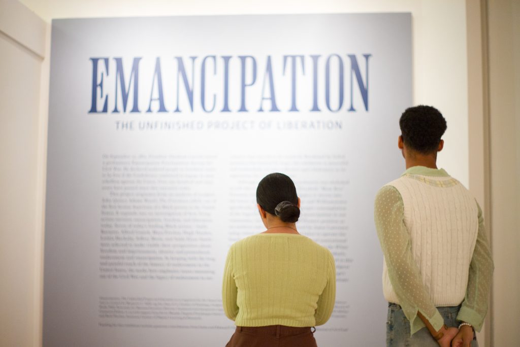 20240229 Emancipation Opening-1009330 two people read the wall label for the Williams College Museum of Art exhibition, Emancipation