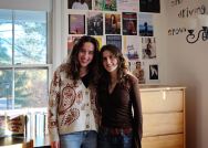 Two college students pose together in their dorm room.