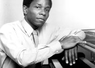 A black and white photo of Clyde Criner at a piano