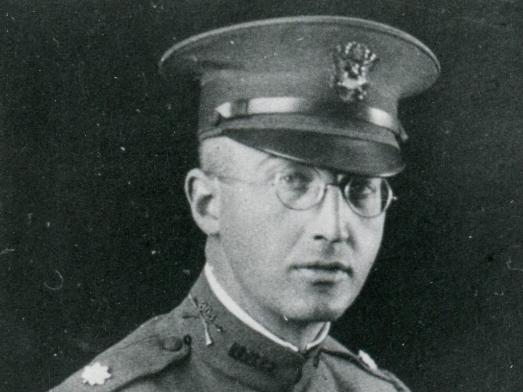 WhittleseyOversizeBoxfront001 Black and white photo of a man in uniform and round wire-framed glasses