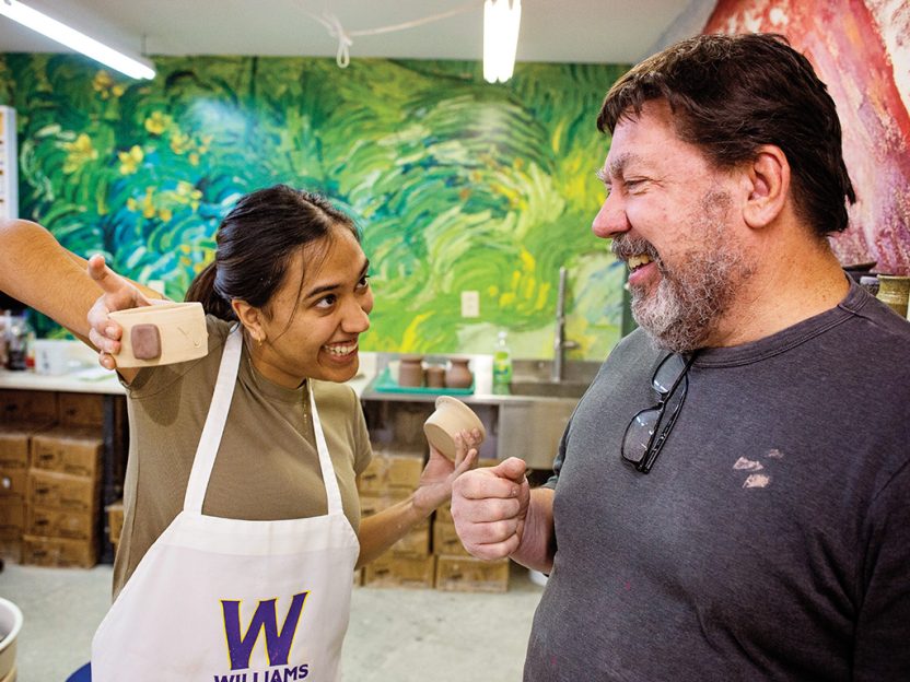 Photo of a student showing her pottery project to her Winter Study instructor